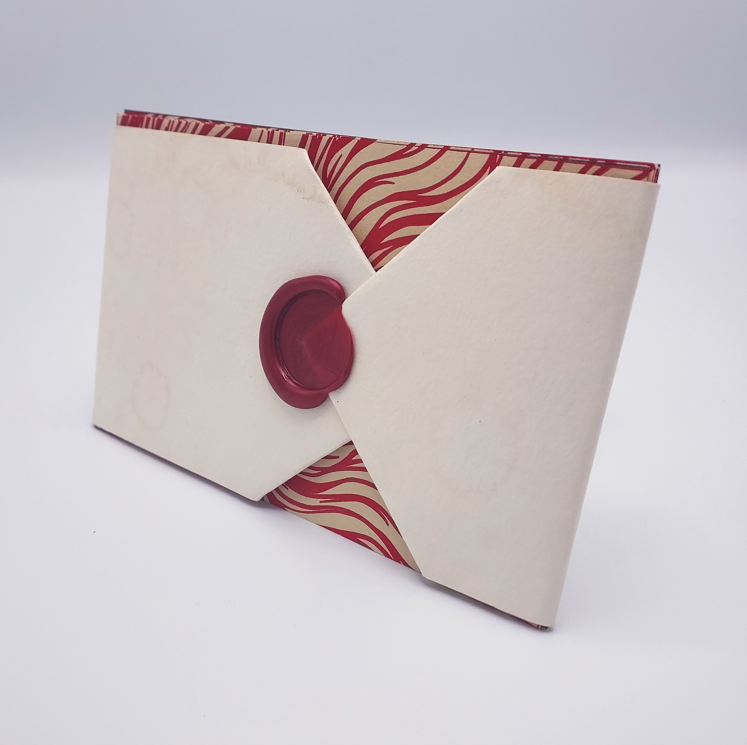 The postcards bound in a sleeve with a wax seal.